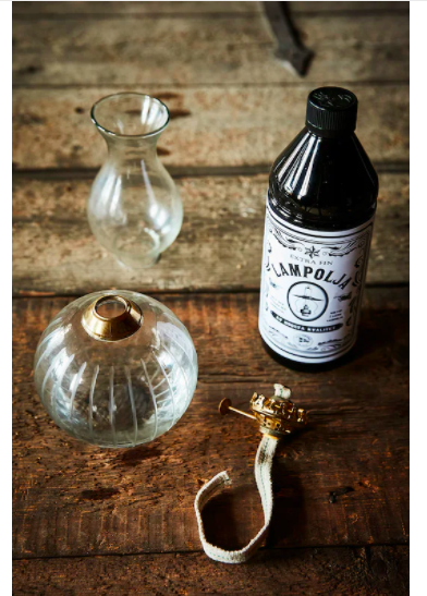 Lampolja 1 Liter i svart flaska från Strömshaga bredvid fotogenlampa i glas
