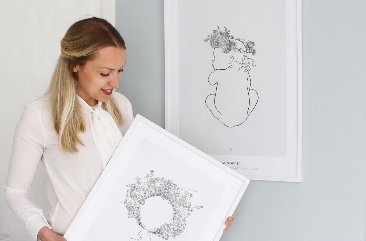 Veronica håller en Floral Crown print framför en Gustav Crown födelsetavla