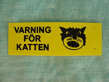 Plastskylt - Varn. för katten (20x7 cm)