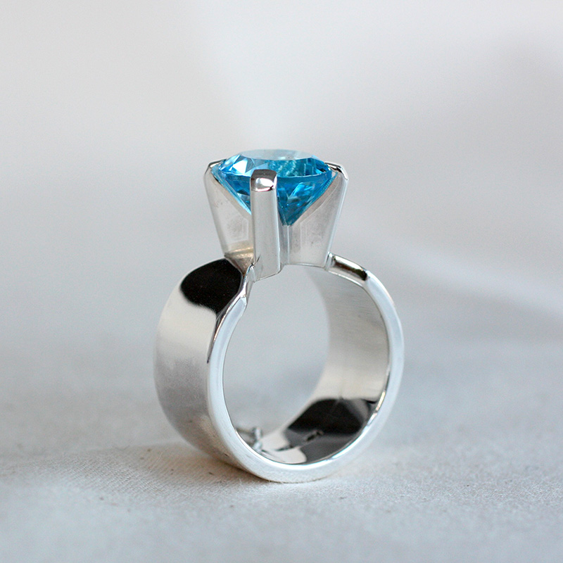 Blänk, bred ring i silver med blå topas