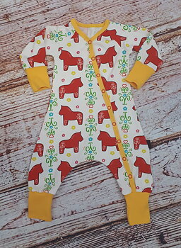 Heldress i vitt med röda dalahästar