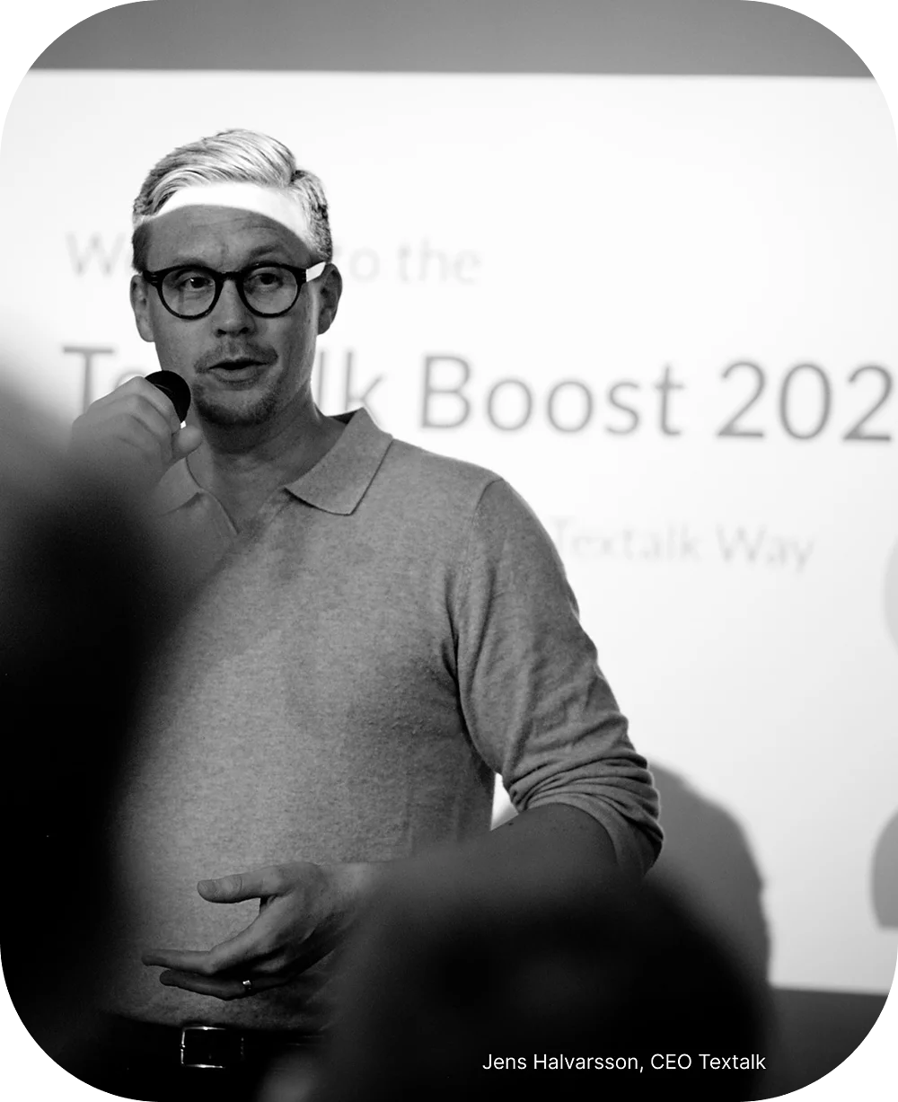 Photo of current CEO Jens Halvarsson speaking into a microphone at Textalk’s annual Boost event for employees.