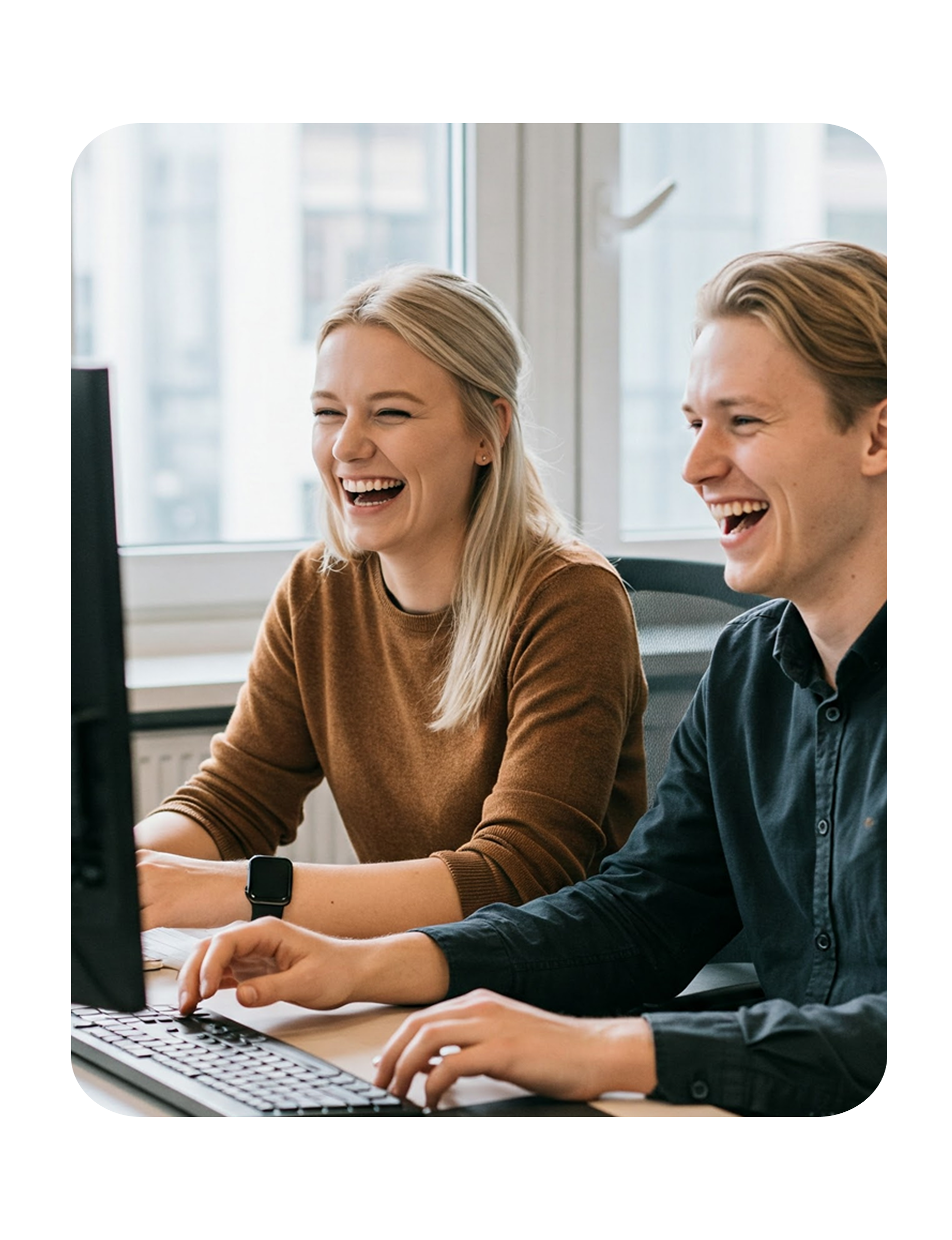 A woman and a man sitting at a computer, working with Textalk’s solutions.