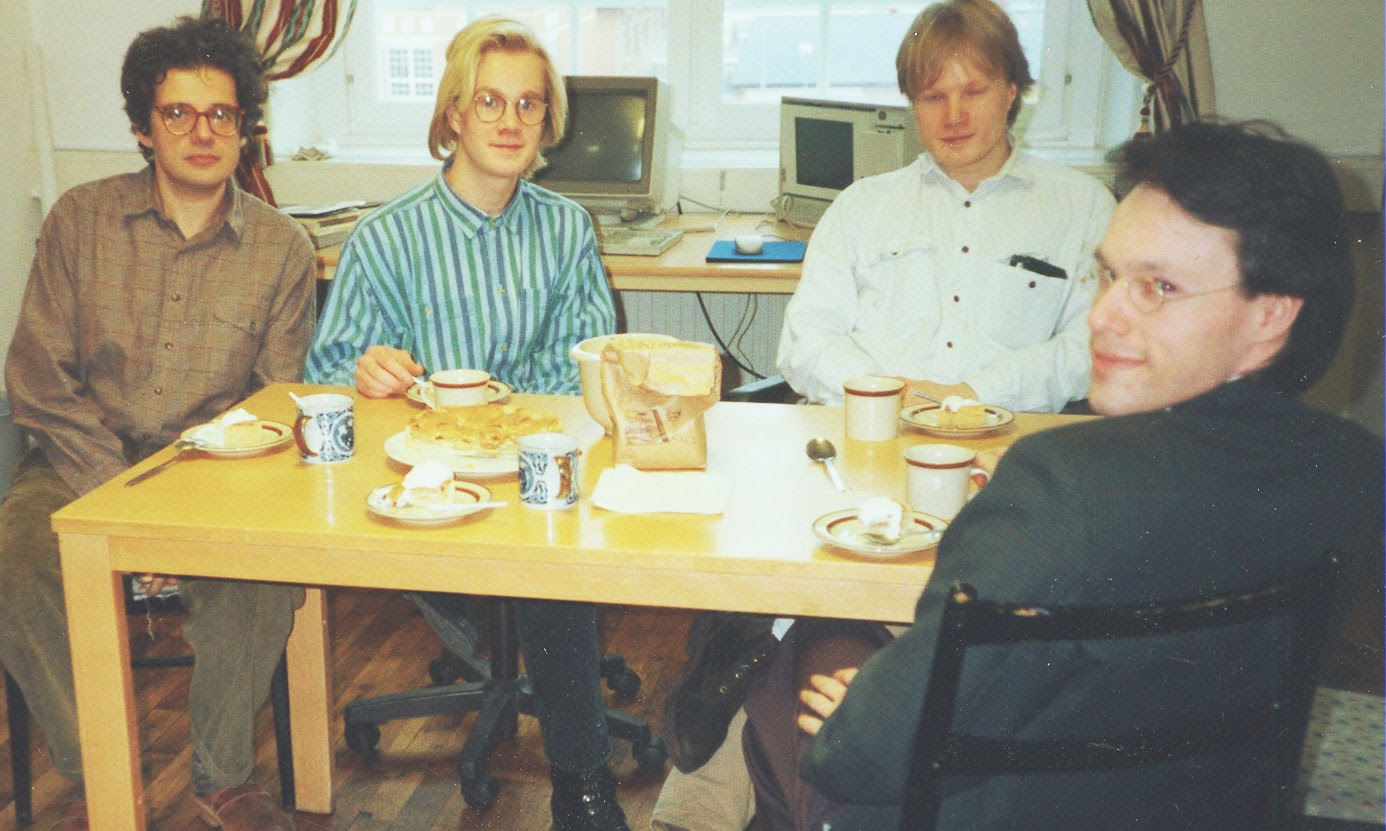 Image shows five men who made up Textalk in the 1990s, sitting around a table having Friday fika.